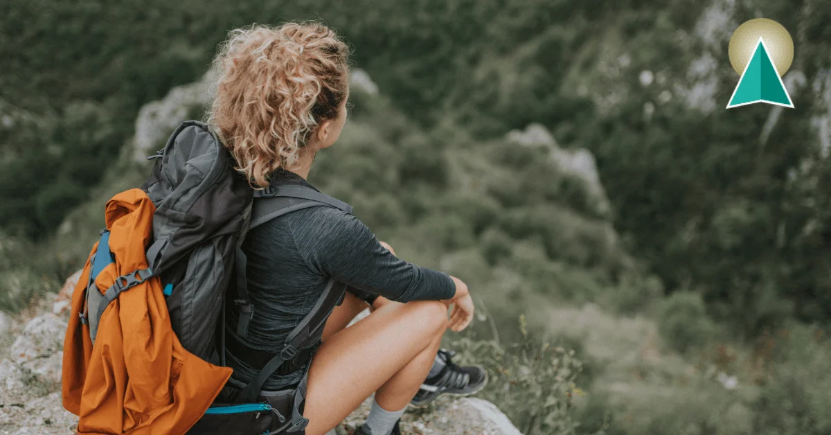 Woman sitting on the edge of a mountain