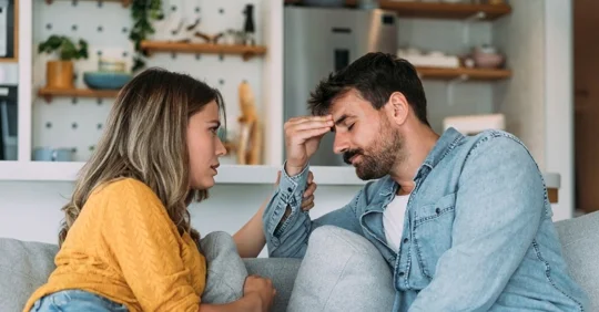 Photo of a couple sitting on the couch, in the middle of an emotional discussion.