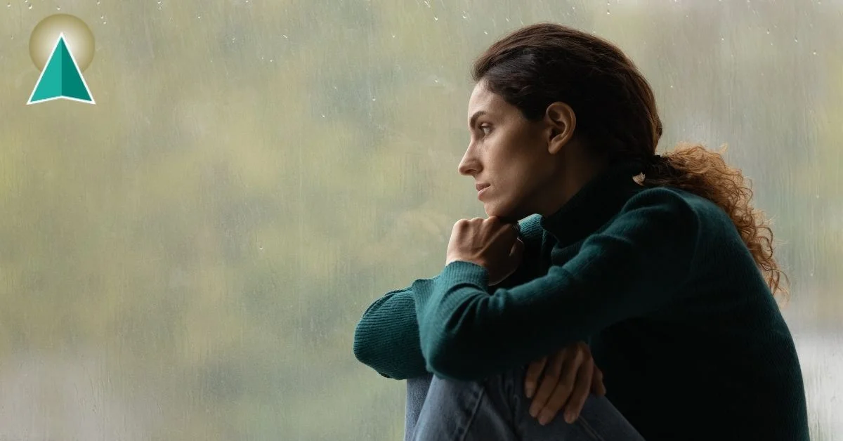 Woman looking out the window at the gloomy day