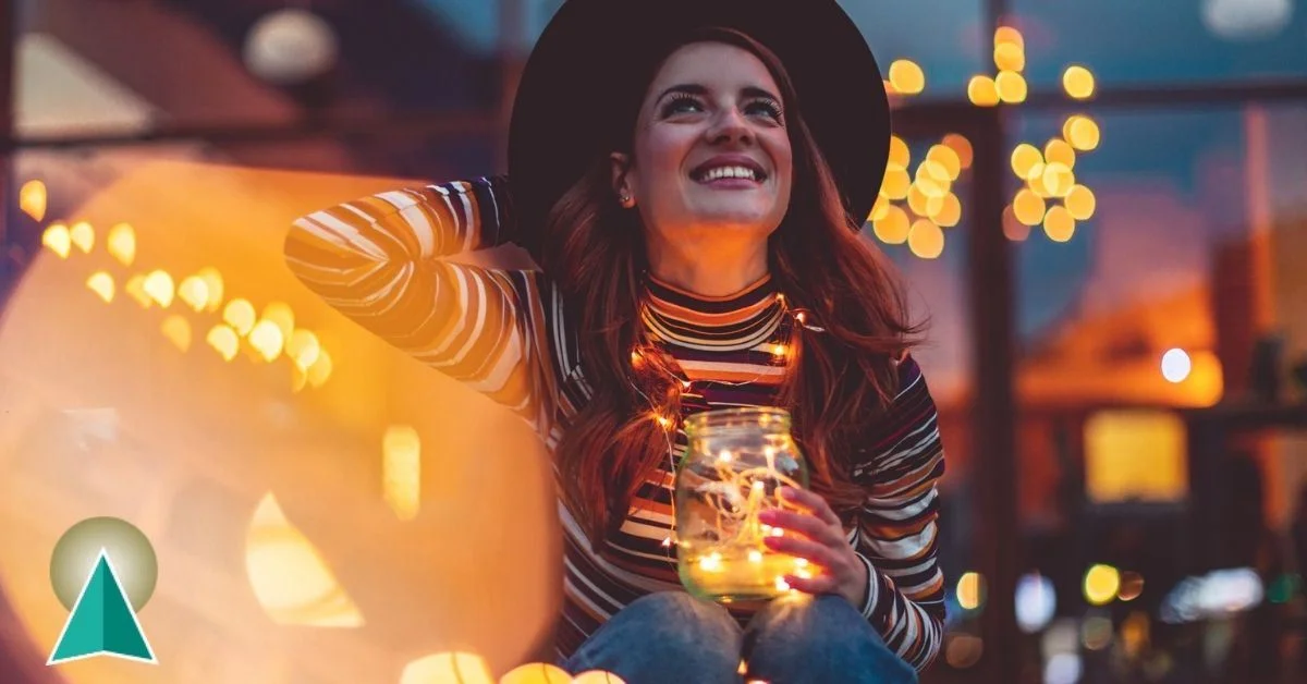 Young female sitting outside holding holiday lights