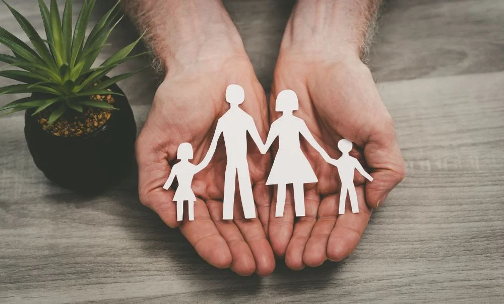 Hands protecting a family