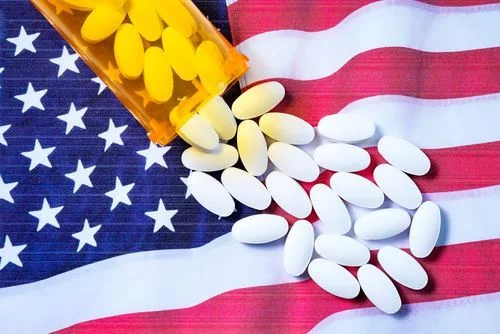spilled bottle of pills over the american flag