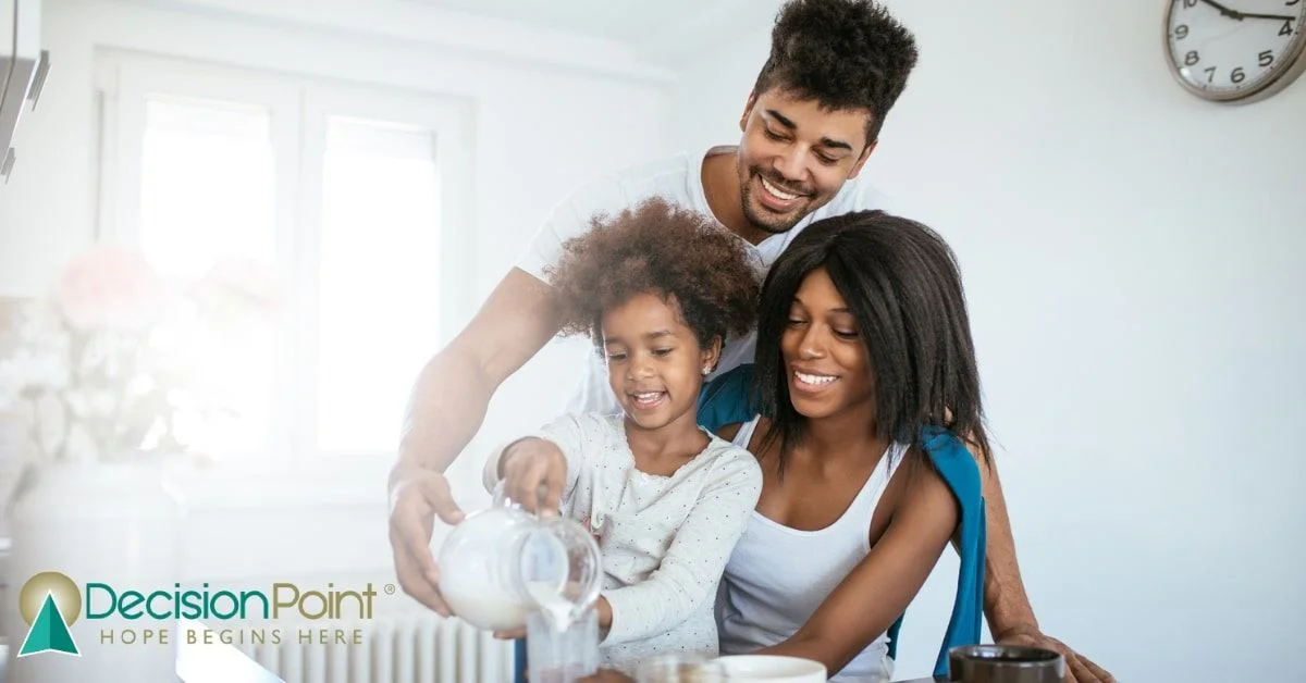 Mom, dad, and older sister holding newborn baby