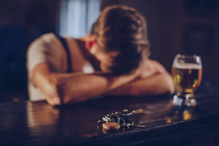 man sitting at bar with heads in his hands