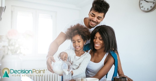 Mom, dad, and older sister holding newborn baby