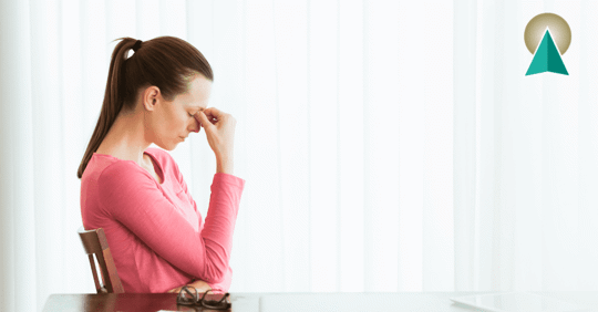 Woman sitting with her head in her hand