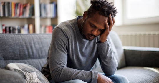 Young man sad with his hand on his head.