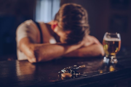 man sitting at bar with heads in his hands