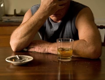 distraught man with cigarette and glass of alcohol