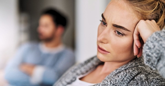 Woman looking upset next to her male partner.