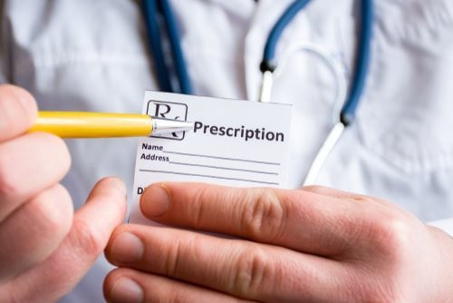 doctor holding a prescription pad and pen