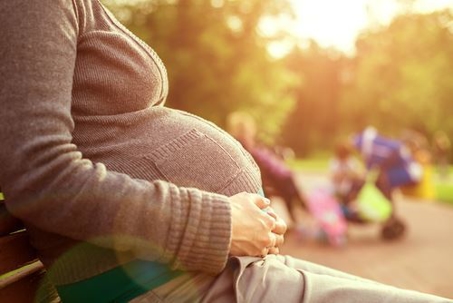 pregnant woman sitting on park bench